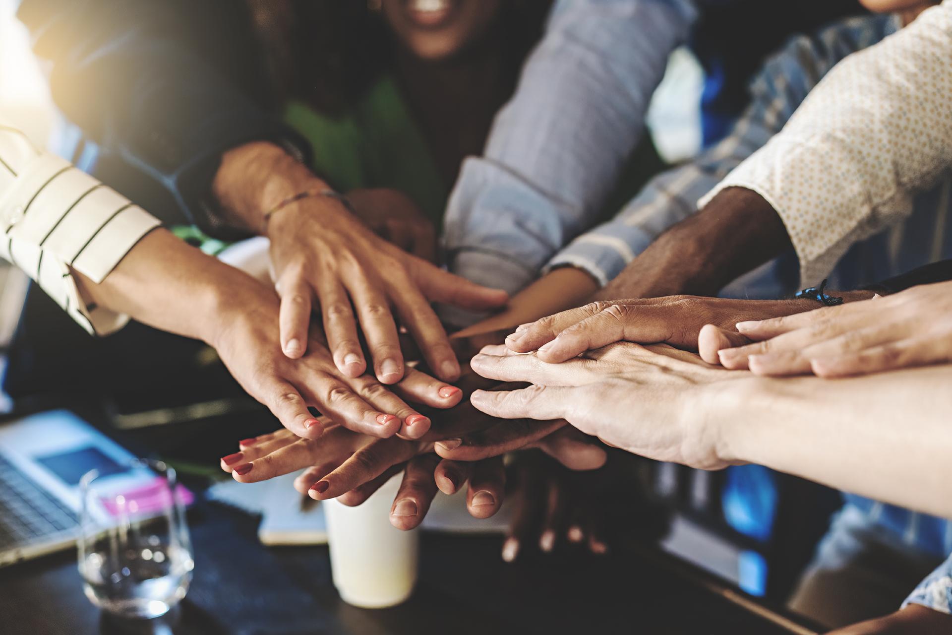 Multiracial group of businesspeople joining hands in stack - cooperation, unity, success and team building business concept